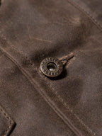 Mesquite vest button detail on dark brown fabric with stitched seam