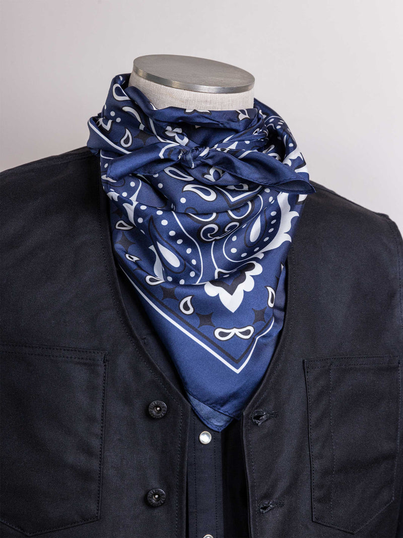 Navy bandana wild rag with white paisley and scroll pattern, draped over collar